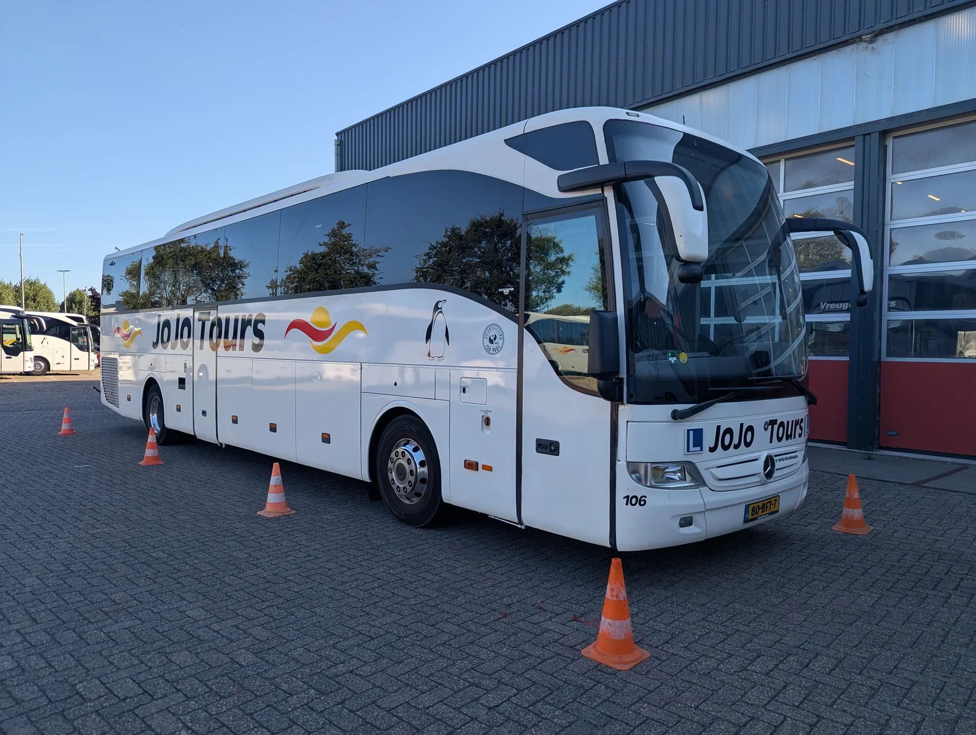 Lesbus van JoJo Tours met pionnen op het oefenterrein Lesbus van JoJo Tours met pionnen op het oefenterrein